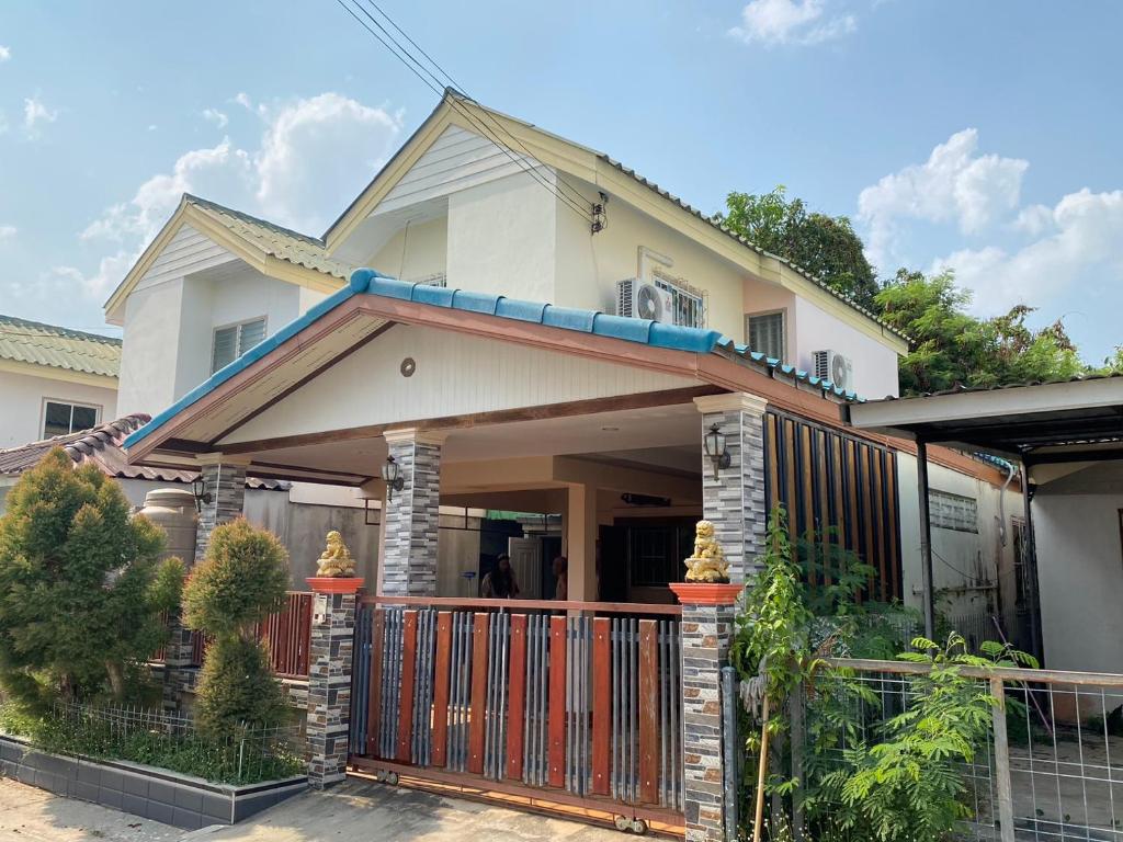 a house with a gate and a fence at Buriram Cozy Home in Buriram