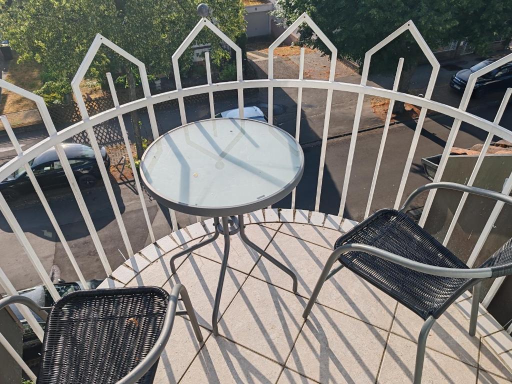 a glass table and two chairs on a balcony at Traumhafte Lage am Kurpark in Bad Nauheim