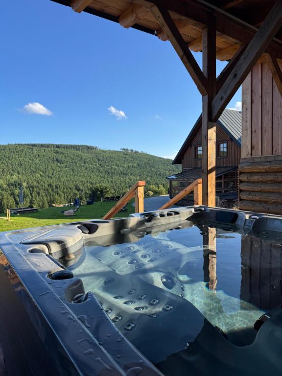 a hot tub on the deck of a log cabin at Hotel Vydrovy boudy, Pec pod Sněžkou in Pec pod Sněžkou