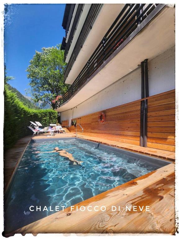 a swimming pool with two people in the water at Chalet Fiocco Di Neve in Pinzolo