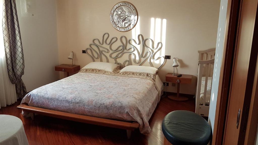 a bedroom with a bed with a large headboard at Rosej Bed & Breakfast Putignano in Putignano