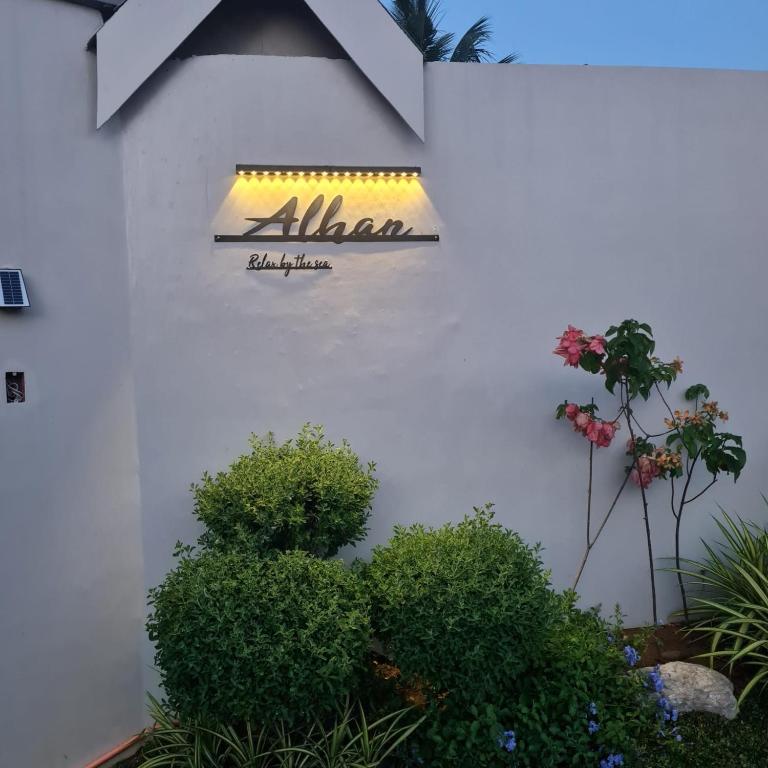a sign on the side of a building with plants at Strand 