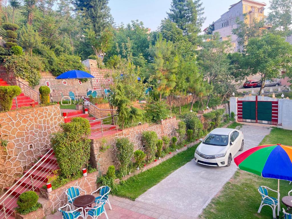 a car parked in a parking lot with an umbrella at BHURBAN view APARTMENTS in Murree