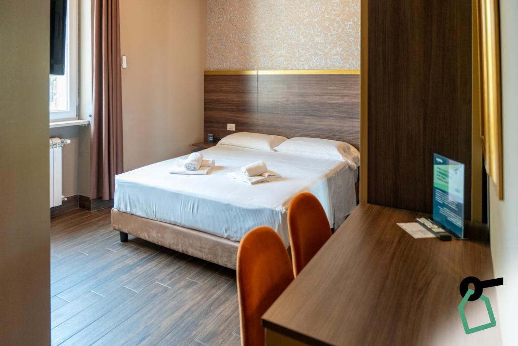 a bedroom with a bed and a desk with a computer at Hotiday Verona Fiera in Verona
