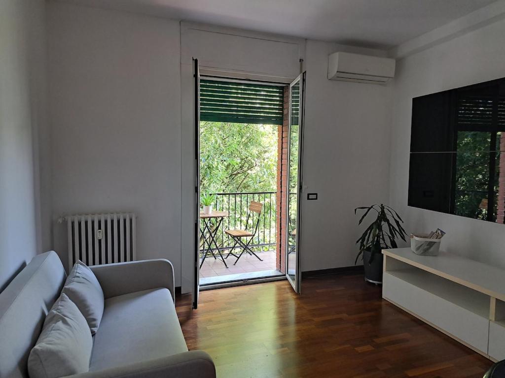 ein Wohnzimmer mit Sofa und Glasschiebetür in der Unterkunft Agrippa 24 in Mailand