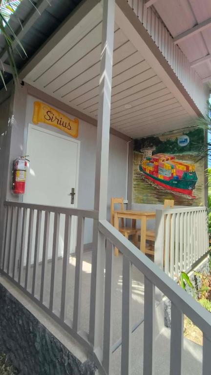 a porch of a building with a table and a boat at TAGBALAYON-GARDEN Guest House in Siquijor