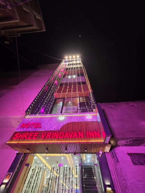 a tall building with a sign on it at night at Hotel Shree Vrindavan Inn in Vrindāvan