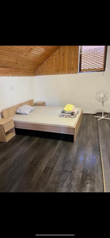 a bedroom with a bed and a wooden floor at Jackys hostel 9 in Sremski Karlovci
