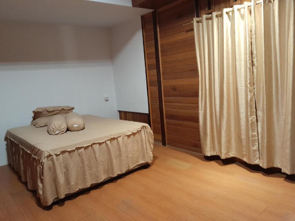 a bedroom with a bed with pillows on it at Homestay Zanoleos in Tomohon