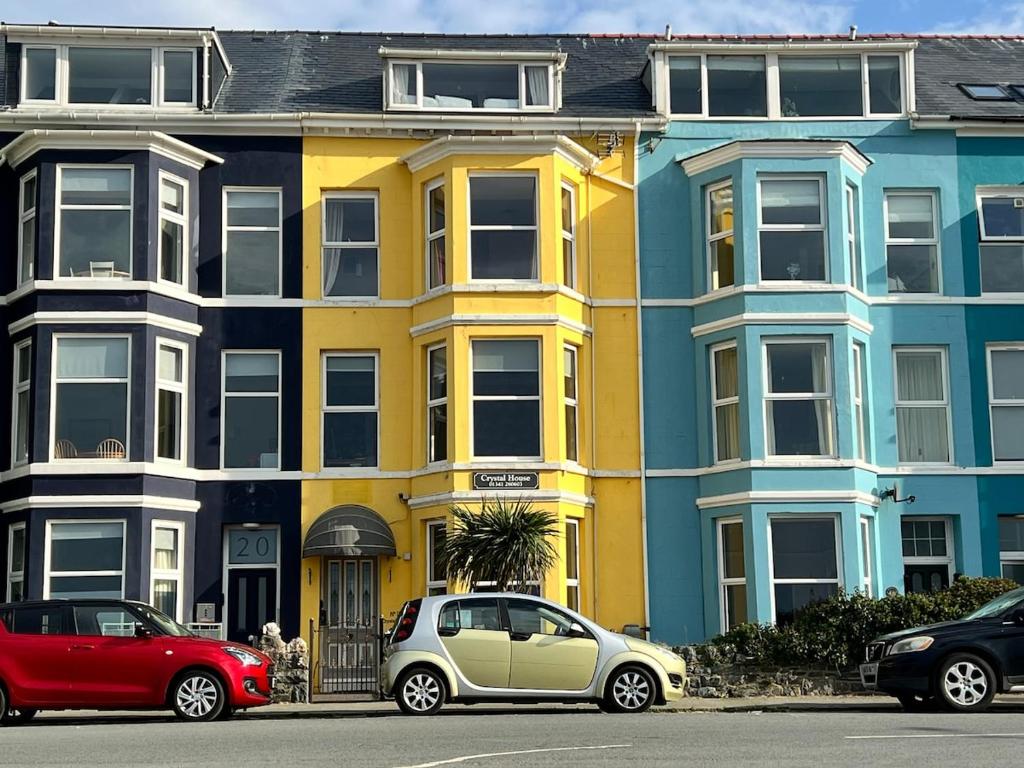 a row of houses with cars parked in front of them at Crystal House in Barmouth