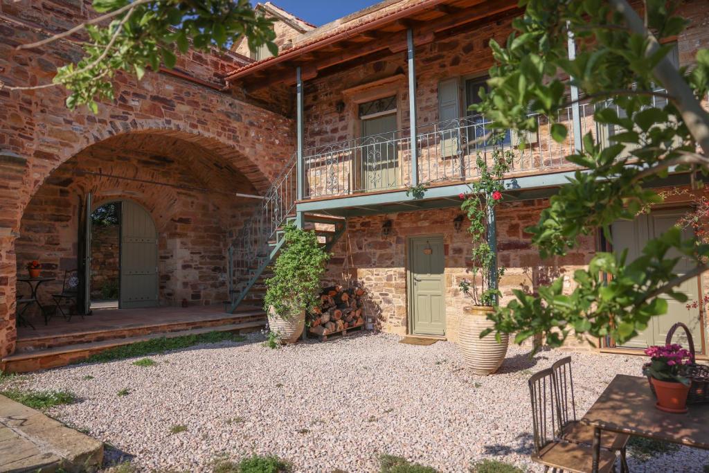 a brick house with a balcony and a patio at Pietra Rossa in Chios