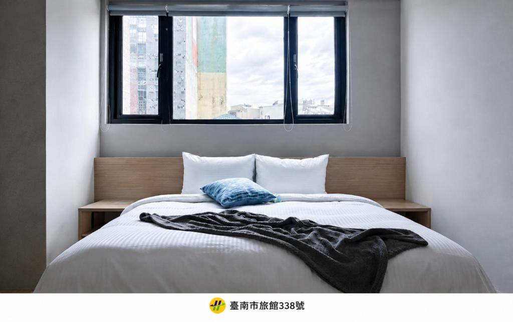 a bedroom with a large bed with a window at 唯爾文旅 - 台南New Velle Voyage Hotel in Tainan