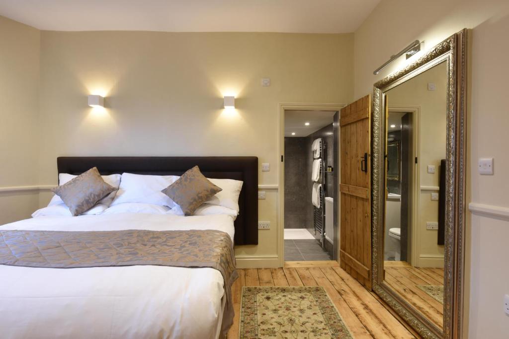 a bedroom with a large mirror and a bed at Sutherland House in Southwold