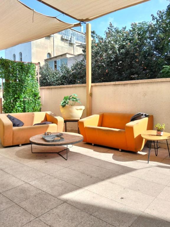 a patio with two couches and a table at Rooms next to Florentine with bomb shelter inside the building in Tel Aviv