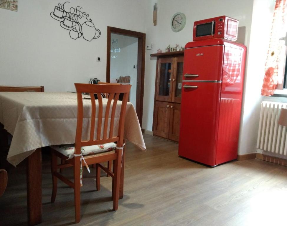 a room with a table and a red refrigerator at Casa Emma in Cremolino