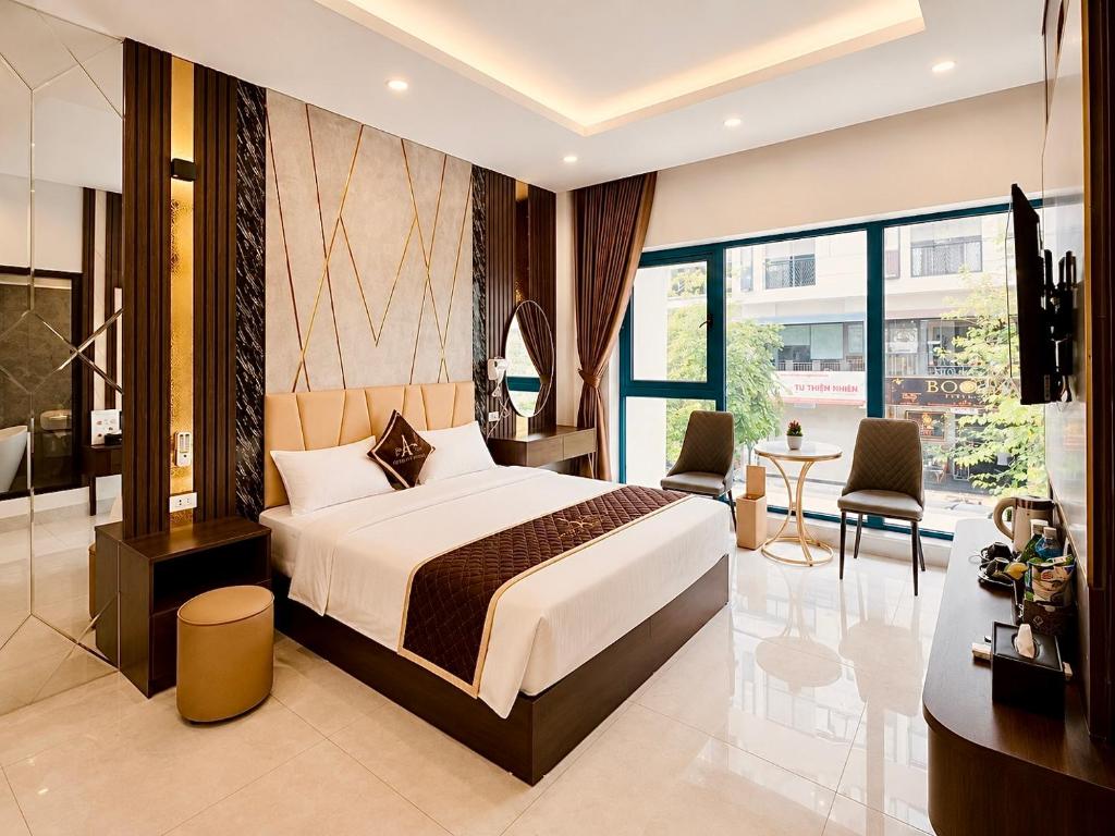 a bedroom with a bed and a table and chairs at PARIS DELI HOTEL - Vạn Phúc in Hà Ðông