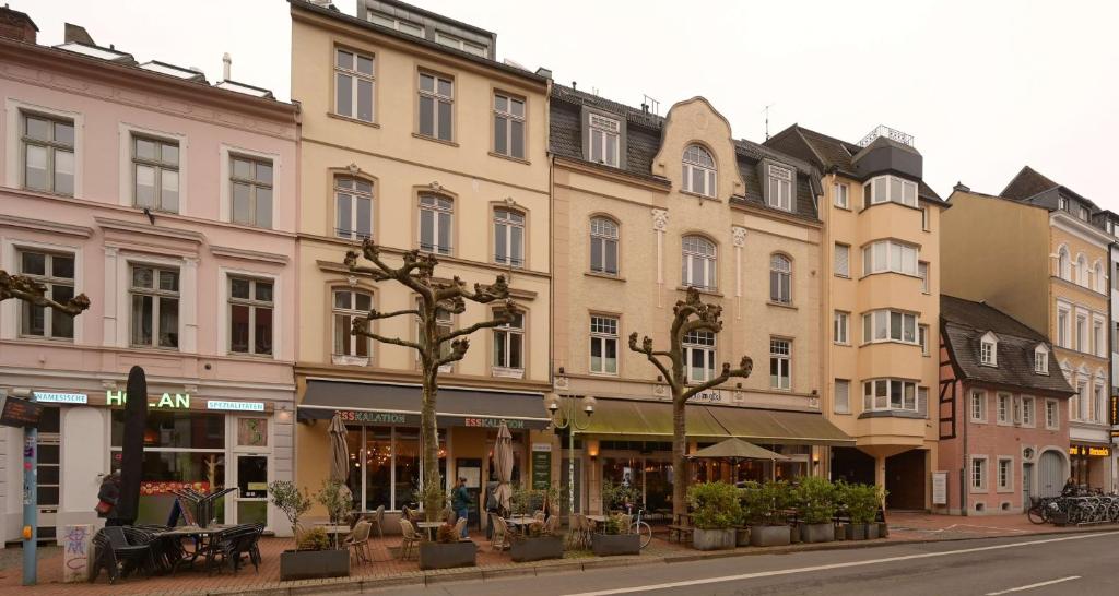 eine Häuserreihe in einer Straße mit Bäumen in der Unterkunft Best Western Hotel President in Bonn