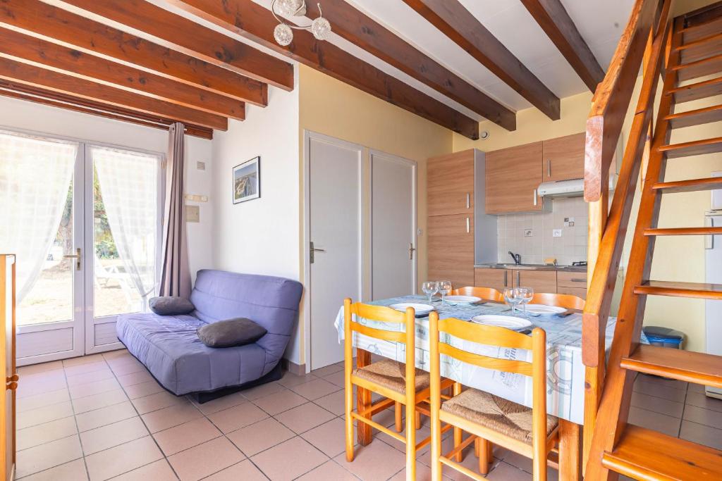 a kitchen and dining room with a table and a couch at Duplex N°5 - Résidence Balnéaire in Le Port-des-Barques