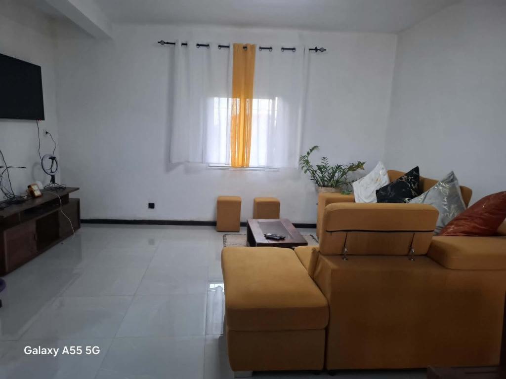 a living room with a couch and a table at Villa TSARAJORO in Toamasina