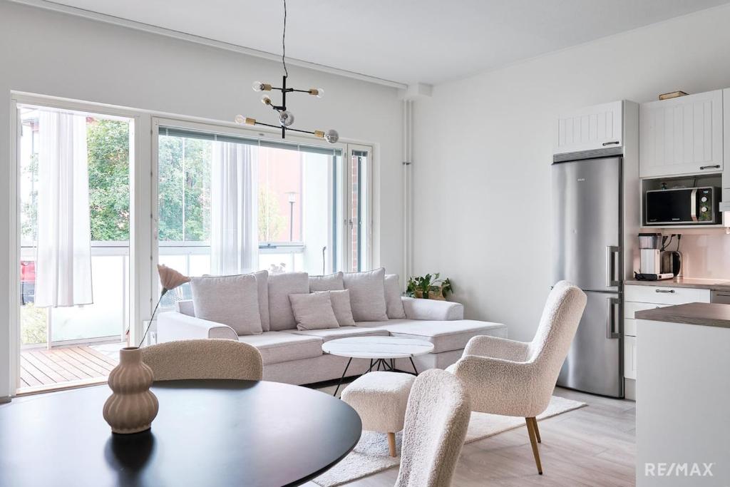 a living room with a couch and a table at Modern two-bedroom apartment in Espoo