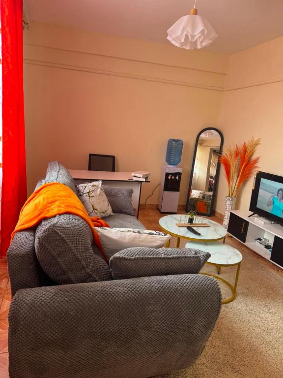 a living room with a couch and a mirror at Sunrise Suites EMBU in Embu