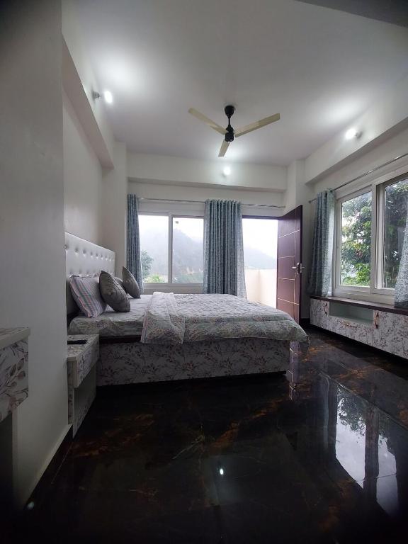 a bedroom with a bed and a large window at Naresh Guest House in Sonprayag