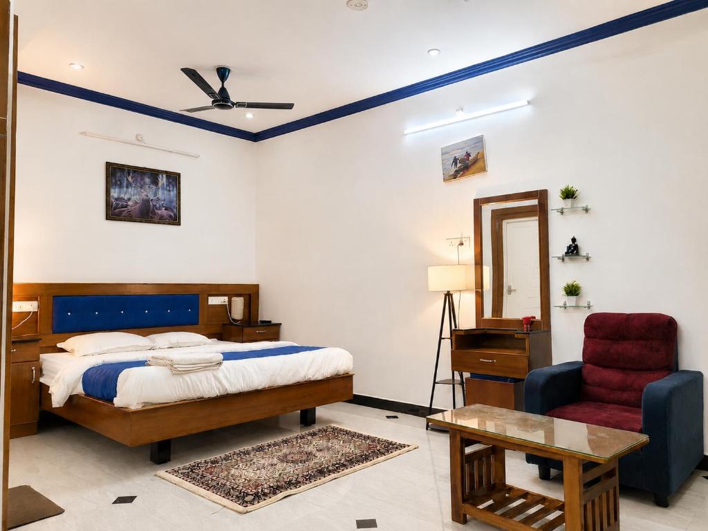 a bedroom with a bed and a chair at Nivaa Stays - Near JIPMER in Pondicherry
