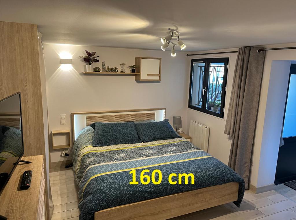 a bedroom with a bed with a cm sign on it at "Le 3 Bis" Climatisé,1 lit King Size in Venoy