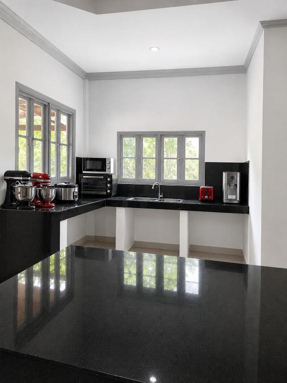 a kitchen with black and white counter tops at Cazabela in Casisang