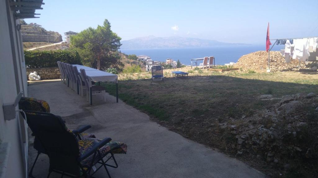 a table and chairs on a porch with a view of the water at Davids Apartments in Sarandë