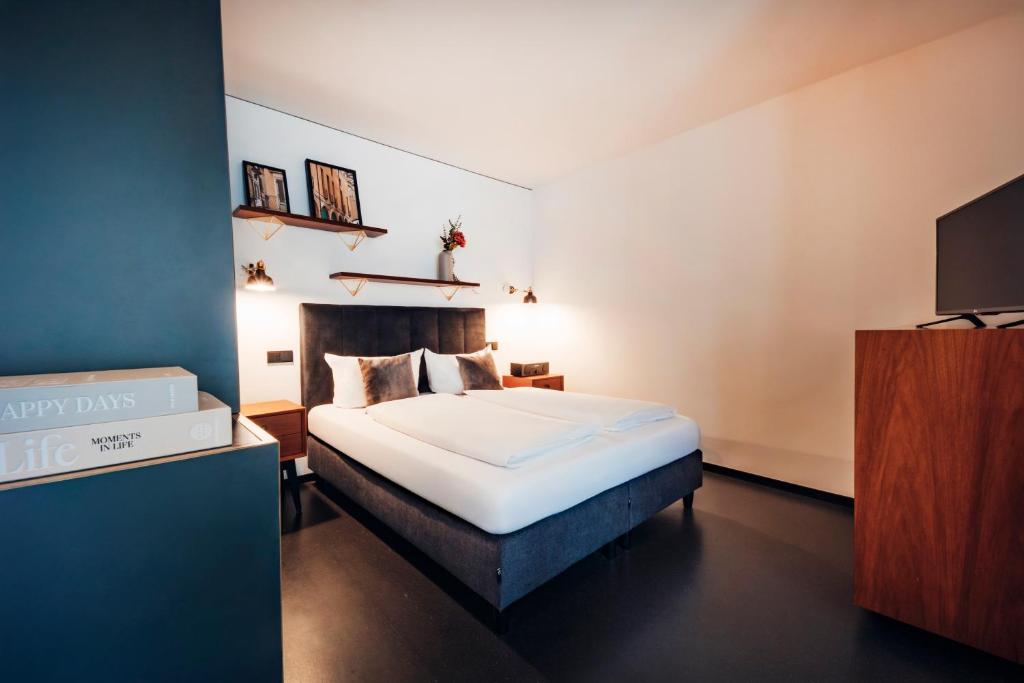 ein Schlafzimmer mit einem Bett und einem Fernseher in der Unterkunft Brera Serviced Apartments Munich Schwabing in München