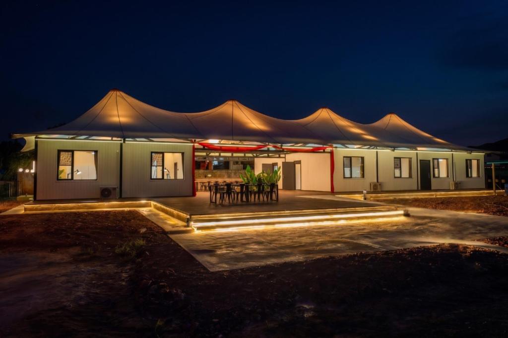 a building with a tent with tables and chairs at Spacious 5BR Canopy Home with Farm in Kepala Batas