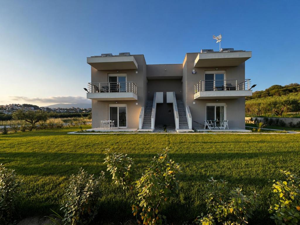 a house with two balconies and a grass field at BELA Apartments Kariani Near Ofrinio in Karianí