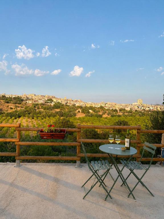 a table with two glasses of wine on a balcony at Eterea Dimora Sul Fiume in Noto