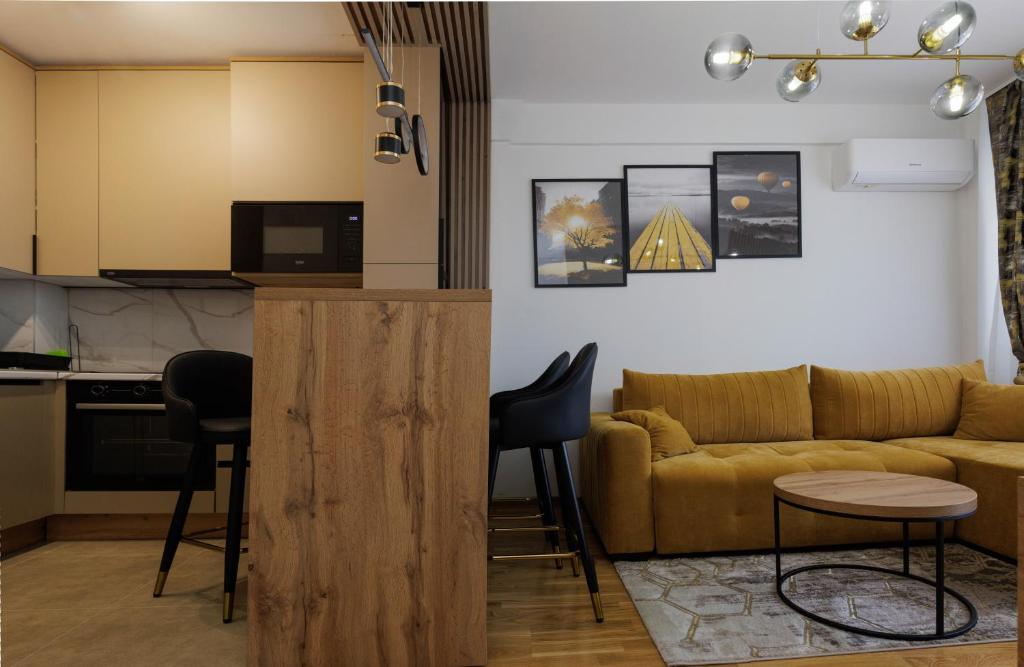 a living room with a couch and a kitchen at Apartmani Savić expres Laktasi in Laktaši