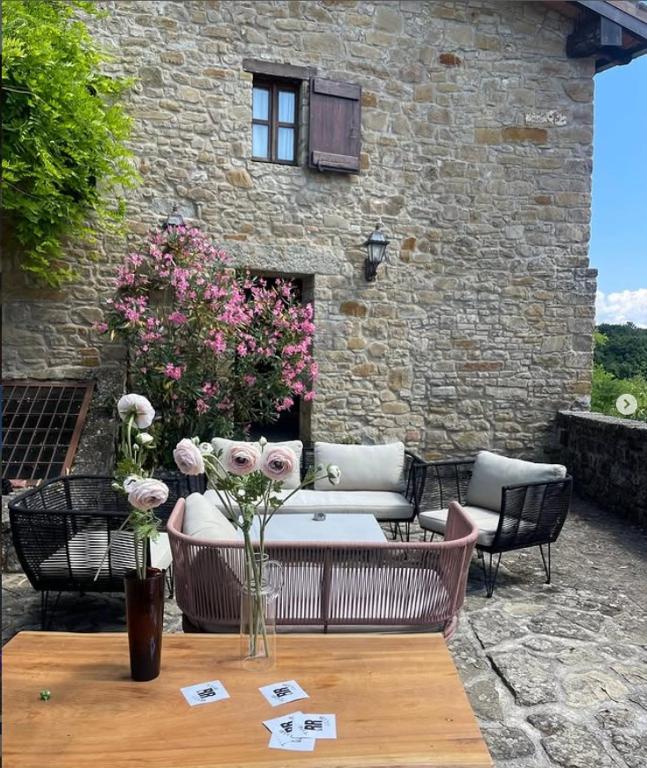 a patio with a couch and flowers on a table at Borgo Vercallo in Case la Selva