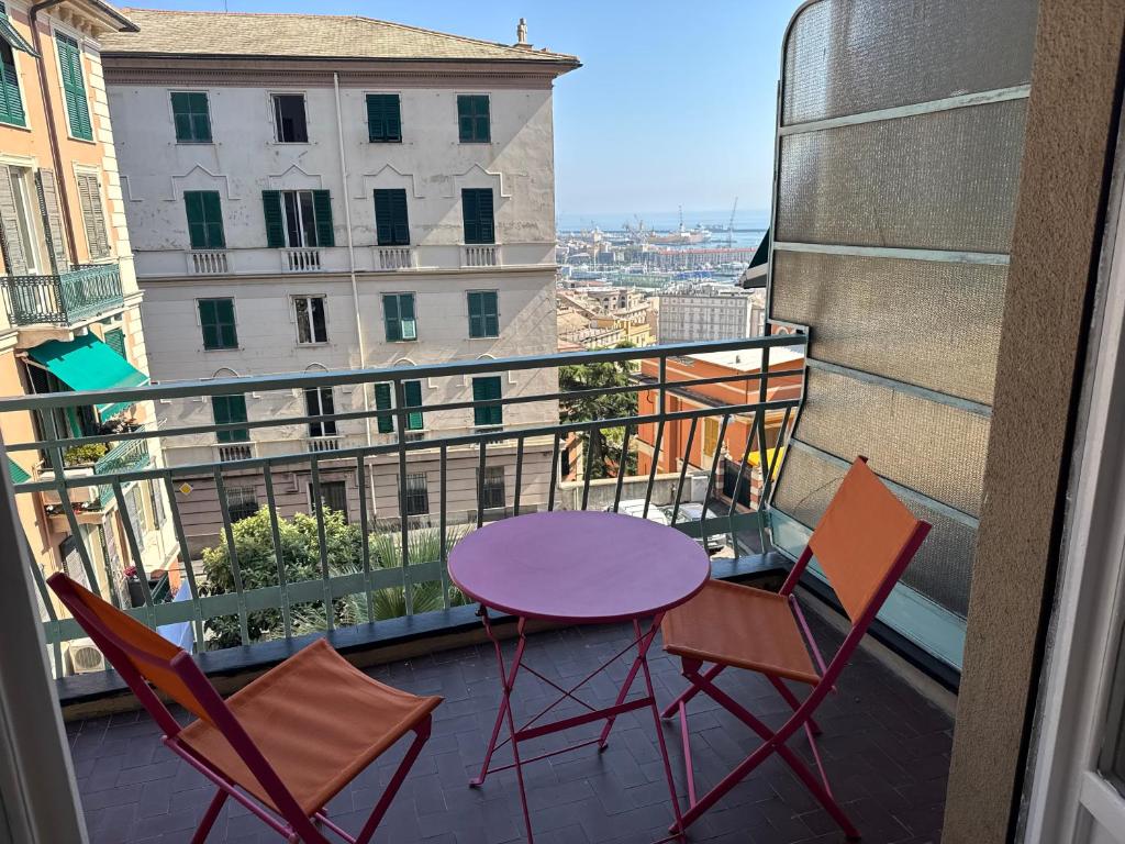 a purple table and two chairs on a balcony at KALEIDO Hostel in Genoa