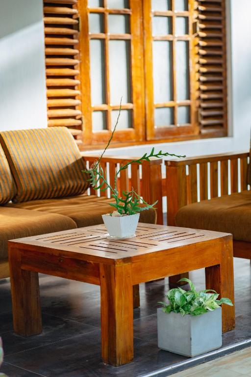 a wooden coffee table with two potted plants on it at Mountain Edge By Yala Odyssey in Kataragama