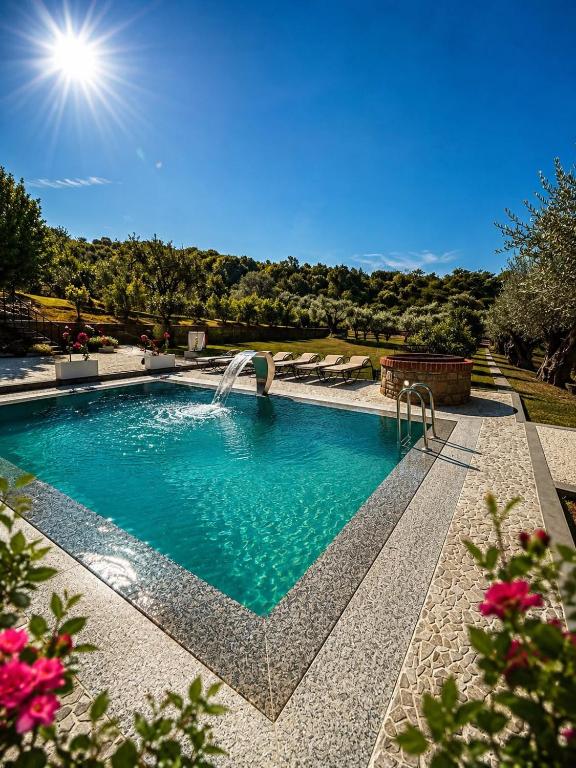 a swimming pool with a fountain in a yard at Villa Kroi i Vashes in Peqin