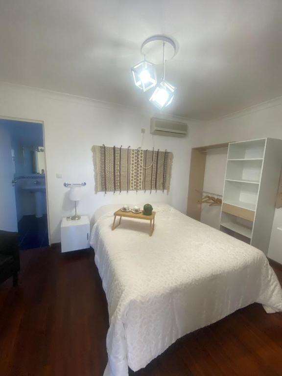a bedroom with a white bed with a table on it at Pinzalez 