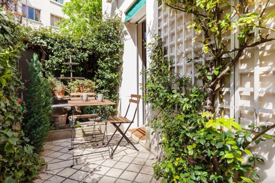 een kleine binnenplaats met een tafel en stoelen bij 1 Square du Docteur Blanche - Paris 16 in Parijs