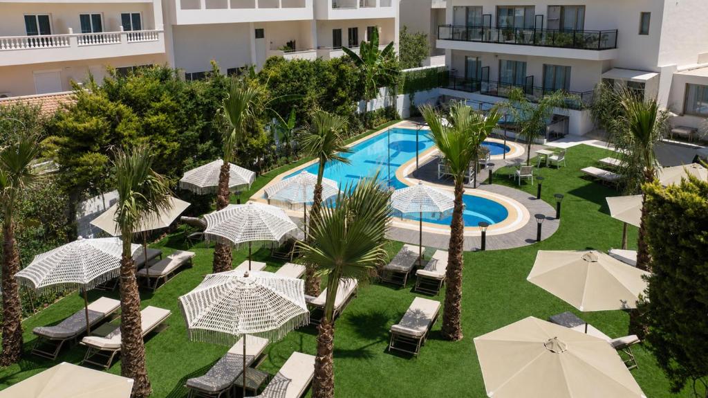 ein Bild vom Pool eines Hotels mit Sonnenschirmen in der Unterkunft Leonidas Hotel & Apartments in Rethymno