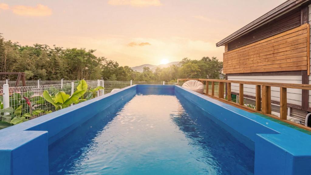 a swimming pool on a deck with a house at boryeong hiddenvillage dokchae poolvilla in Boryeong
