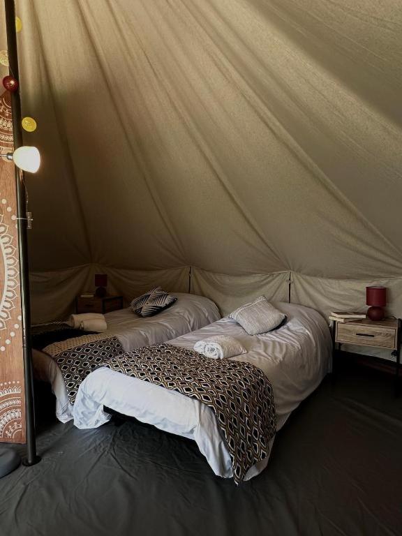 a room with two beds in a tent at Tente lodge in Brassac
