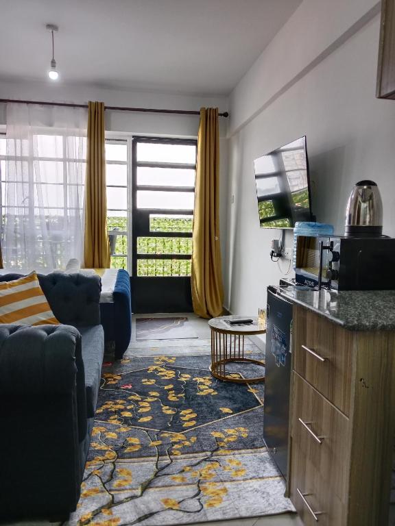 a living room with a couch and a living room with a tv at Relax Crib Nairobi in Nairobi