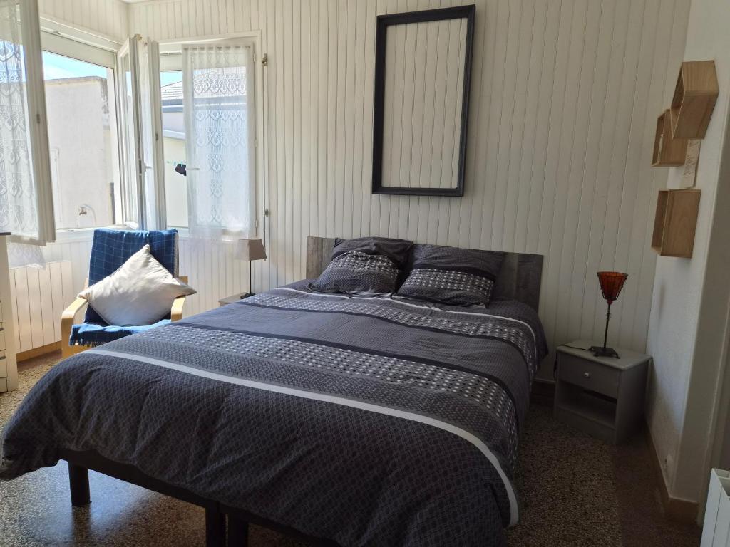 a bedroom with a bed and a mirror on the wall at Studio Calme in Ouistreham