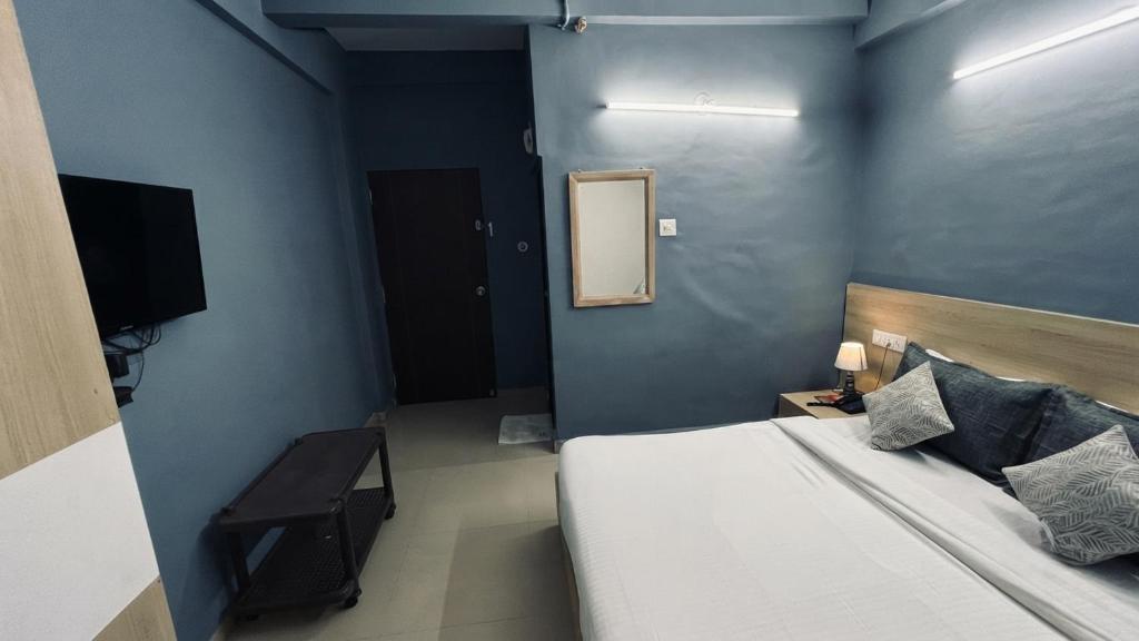 a bedroom with a bed and a mirror and a television at FabHotel Metro Stay in Kolkata