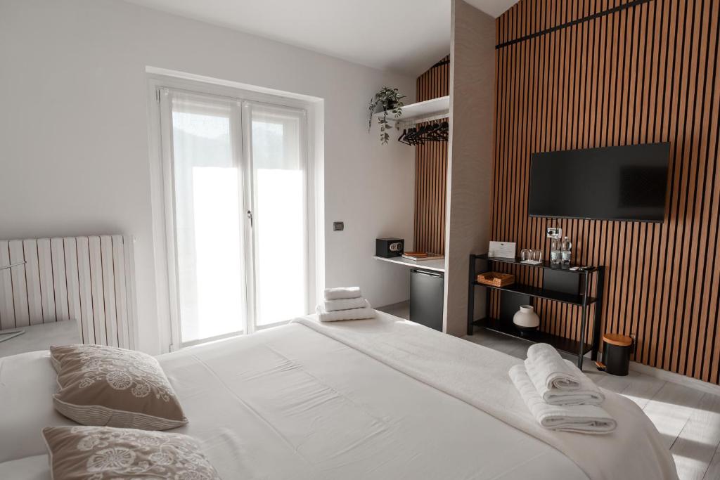 a bedroom with a large white bed and a television at Lario Panorama in Colico