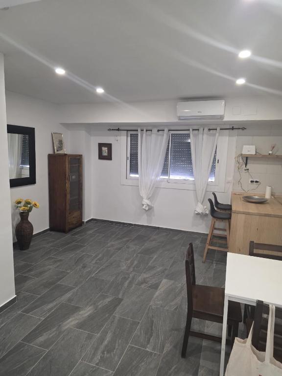 a white room with a table and chairs and a window at Apartamento Centro in Rubí