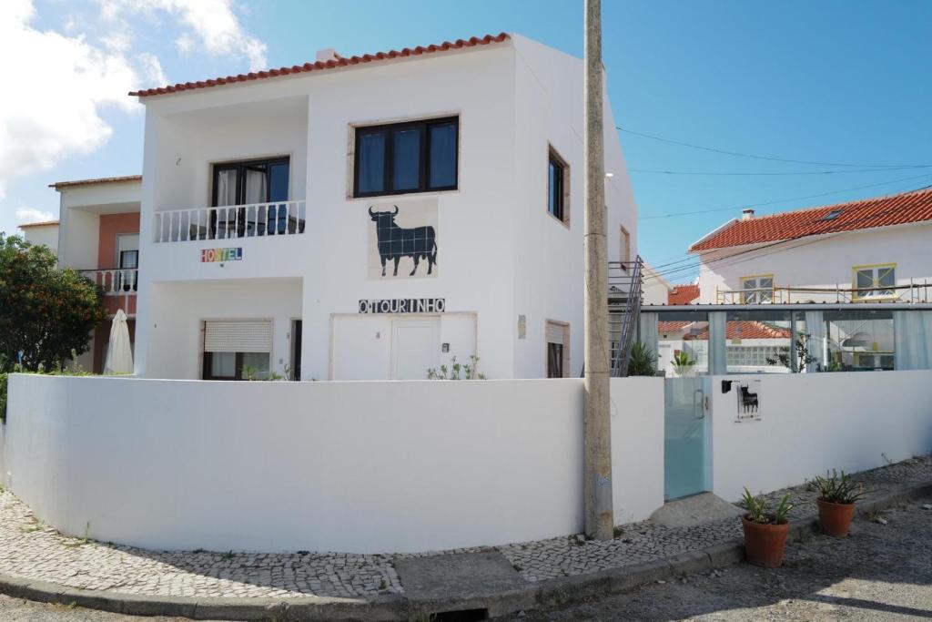 a white house with a white fence at O Tourinho Baleal in Baleal